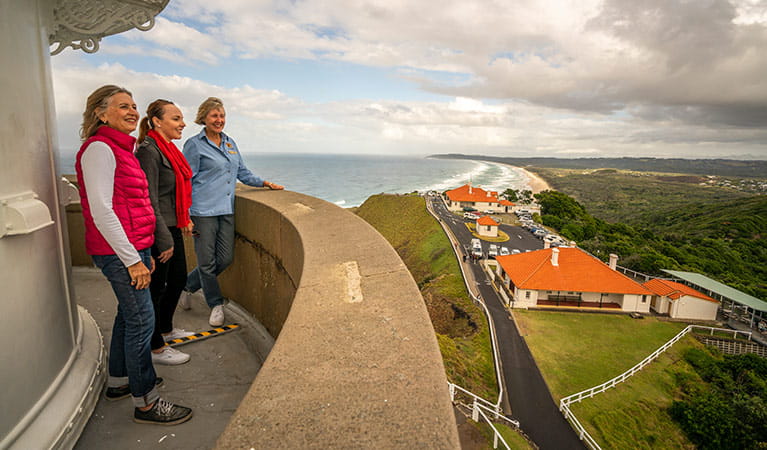 photo of people standing at the top of Cape Byron Lighthouse, overlooking Byron Bay